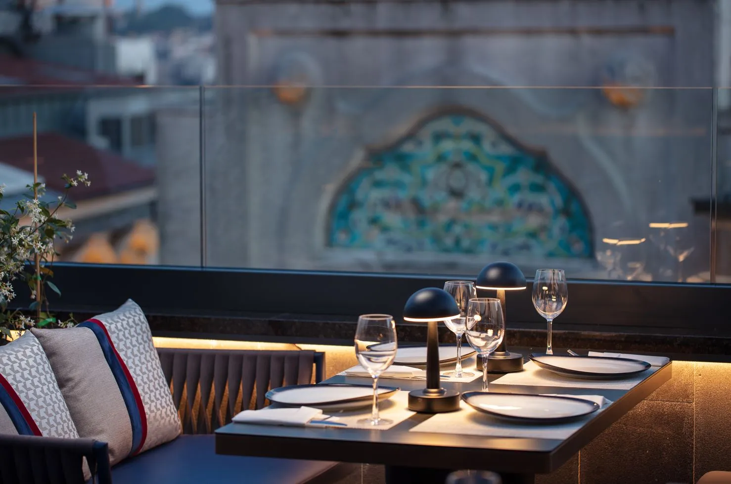 A set table on the Nissim terrace with a tiled historic façade in the background