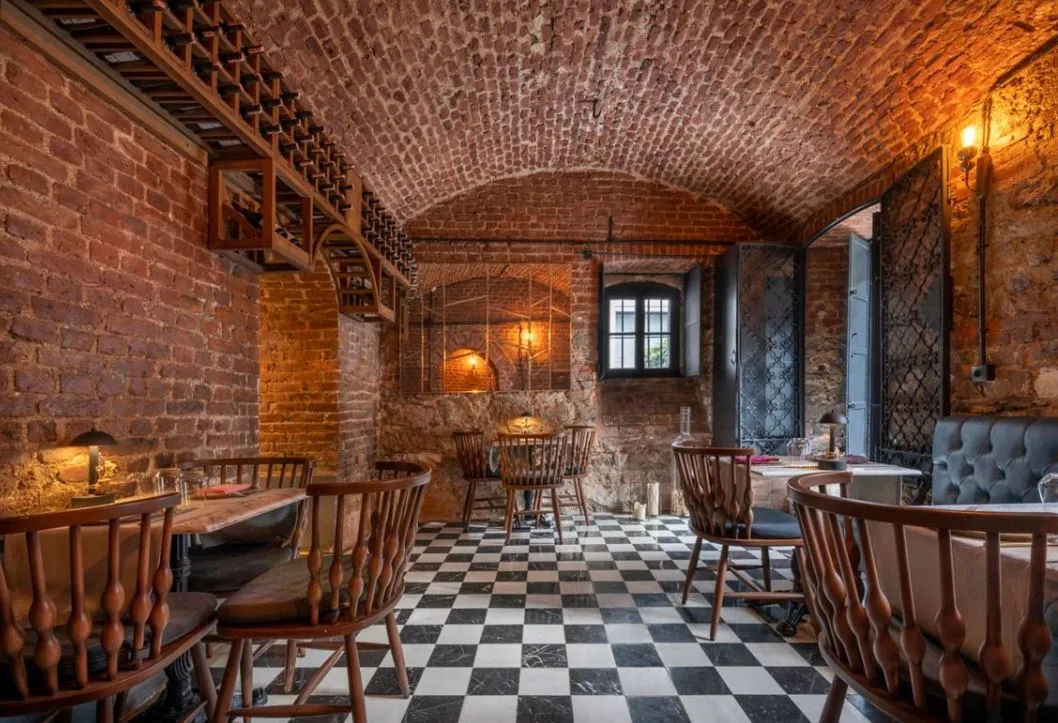 Vigneron Wine House: a vaulted brick cellar with wine racks and a checkerboard floor
