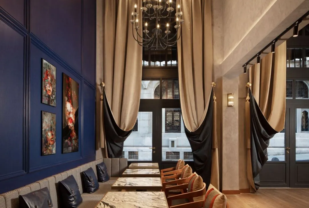 Lounge with tall windows, drapes and a chandelier