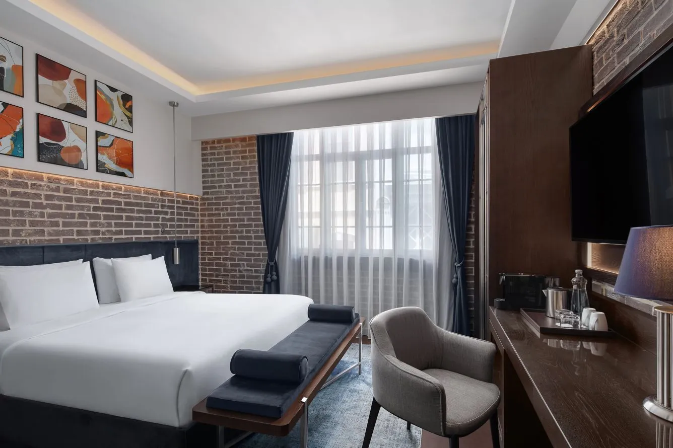 Karaköy Banque Standard room with a double bed and exposed grey brick