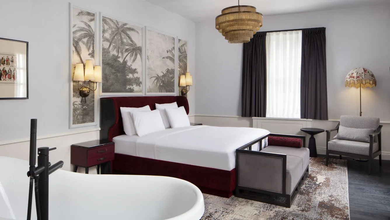 Adahan Family Suite bedroom with a king bed and freestanding bathtub