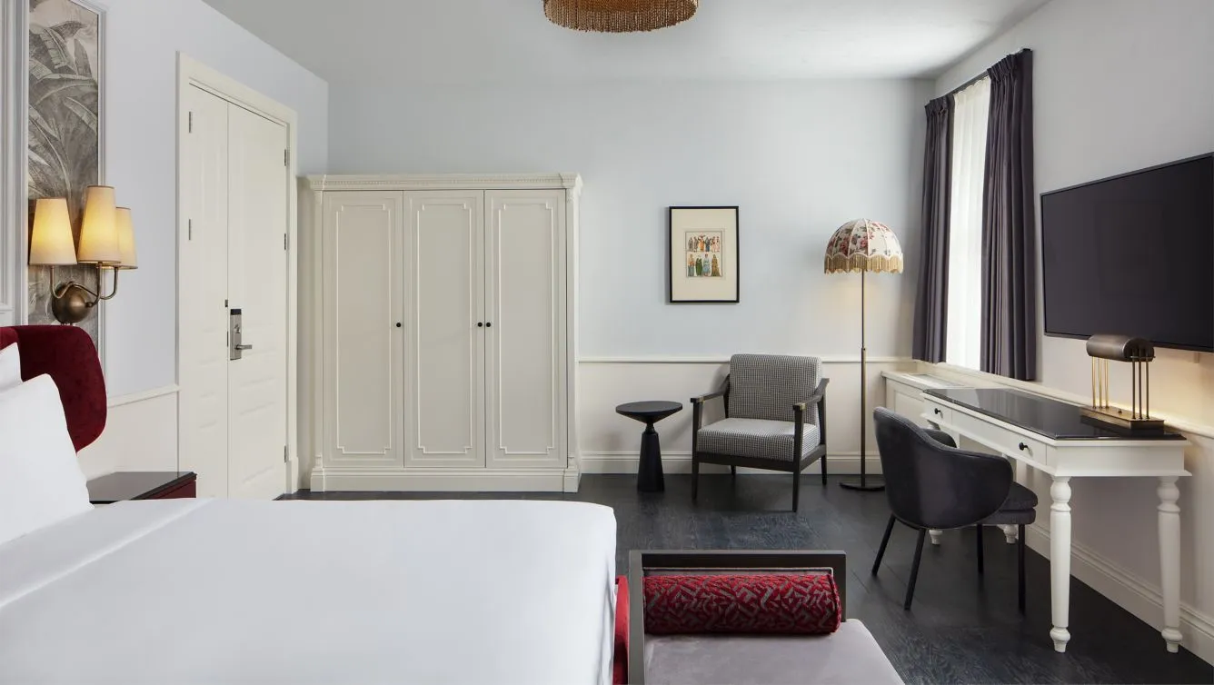 Deluxe King room with a king bed, desk and armchair by the window